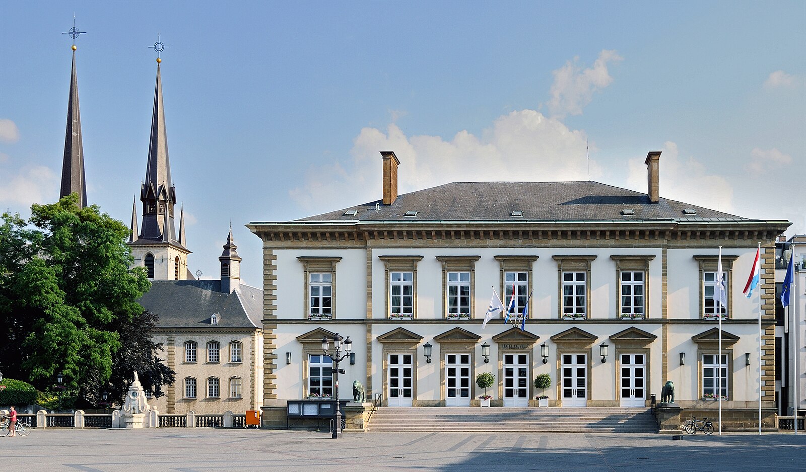 Hôtel de Ville (City Hall) in Luxembourg City with twin spires of Notre-Dame Cathedral in the background.