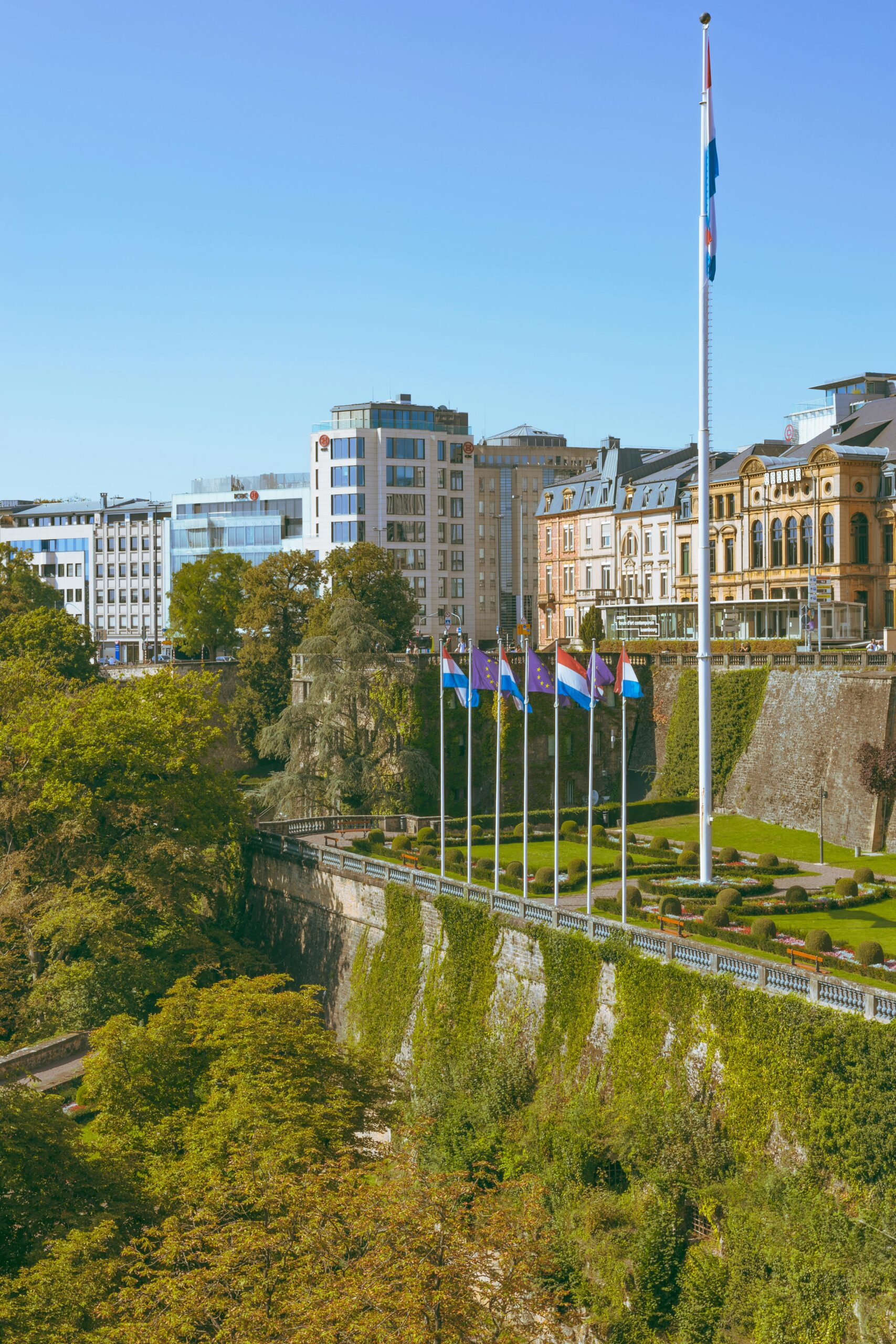 Luxembourg City flags along Pétrusse Valley gardens with city buildings in the background