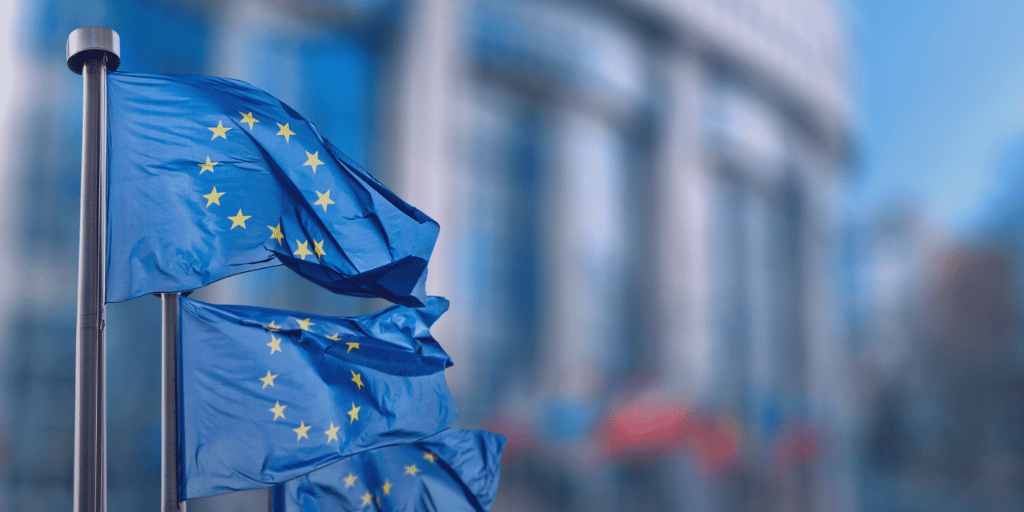 Conceptual photo by symbiot / Shutterstock showing legal scales and EU flag, symbolizing European Union law.